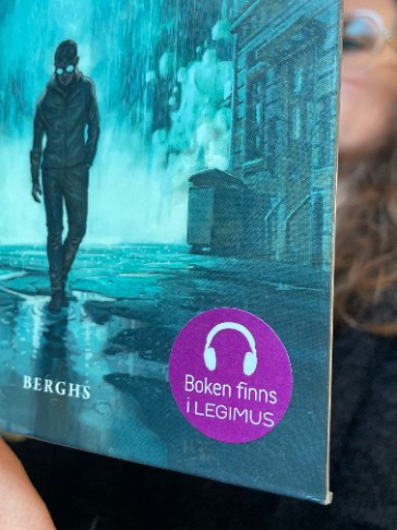 Ett bokomslag med ett klistermärke där det står att boken finns i Legimus. Bilden är länkad till Läs och beställ på mtm.se.